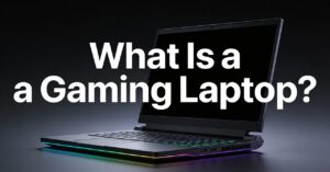 A sleek gaming laptop with glowing RGB keyboard and base sits on a dark surface. Bold white text over the laptop reads "What Is a Gaming Laptop?"