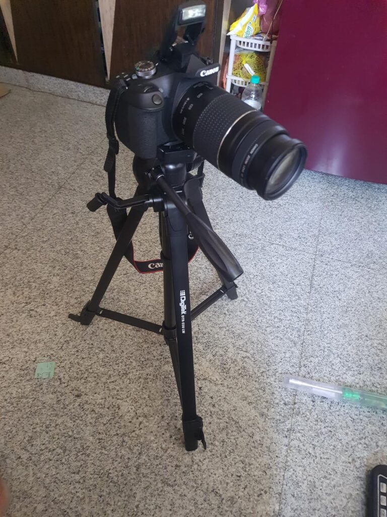 Digitek DTR 550 LW tripod holding a Canon DSLR camera for indoor photography setup